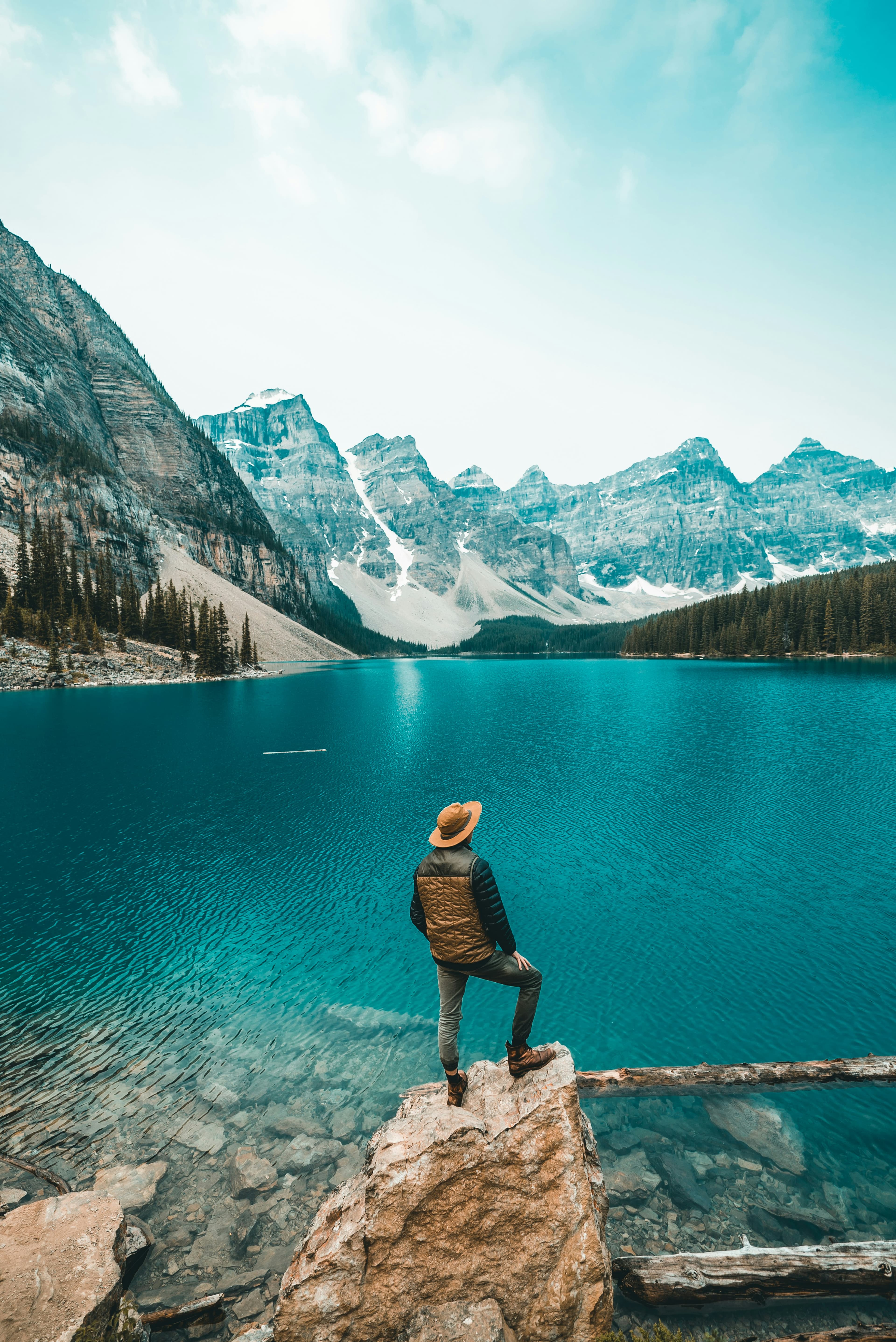 Traveller overlooking turquoise Moraine Lake surrounded by snow-capped mountains